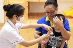 A healthcare worker administers a measles vaccine to a child at a vaccination site in Hanoi. (Photo: VNA)