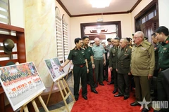 General Phan Van Giang presents foreign defence and military leaders with a photo exhibition showcasing activities commemorating the 80th anniversary of the August Revolution and National Day on September 2. (Photo: qdnd)
