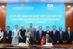 Chairman of the Binh Dinh provincial People’s Committee, Pham Anh Tuan (sitting, right), and the CEO of Syre Group sign a memorandum of understanding on investment cooperation on April 25. (Photo: nld)