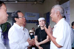 Nguyen Van Nen, Politburo member and Secretary of the Ho Chi Minh City Party Committee (second from left), offers condolences to the families of the victims in the Doc Lap apartment fire. (Photo: VNA)