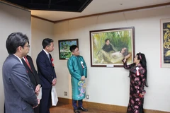 Painter Van Duong Thanh introduces her painting of President Ho Chi Minh (Photo: VNA)