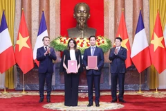 On the morning of May 26, 2025, following bilateral talks at the Presidential Palace, President Luong Cuong (first, right) and French President Emmanuel Macron (first, left) witness the exchange of cooperation documents between leaders of ministries, agencies, and enterprises from both countries. In the photo: Ngo Chi Dung, General Director and Chairman of the Board of Viet Nam Vaccine Company (VNVC) (second, right), and Zainab Sadat Qayyum, President of Sanofi Southeast Asia – India, exchange the cooperation agreement on the transfer of Sanofi’s vaccine production technology to VNVC’s vaccine and biologicals plant. (Photo: VNVC)