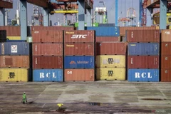 An officer walks beside a pile of containers in the Jakarta International Container Terminal (JICT) area, Jakarta. (Photo: Antara)