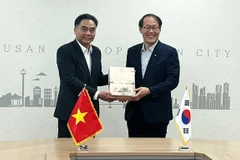 Vice Chairman of the HCM City People's Committee Nguyen Loc Ha (L) presents a commemorative gift to Busan Vice Mayor Lee Jun-seung. (Photo: Sggp)