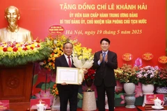 State President Luong Cuong presents a 40-year Party membership badge to Le Khanh Hai, member of the Party Central Committee and head of the Presidential Office at a ceremony on May 19 in Hanoi. (Photo: VNA)