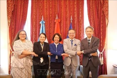 Vietnamese Ambassador Ngo Minh Nguyet (middle) poses for a photo with delegates at the event. (Photo: VNA)