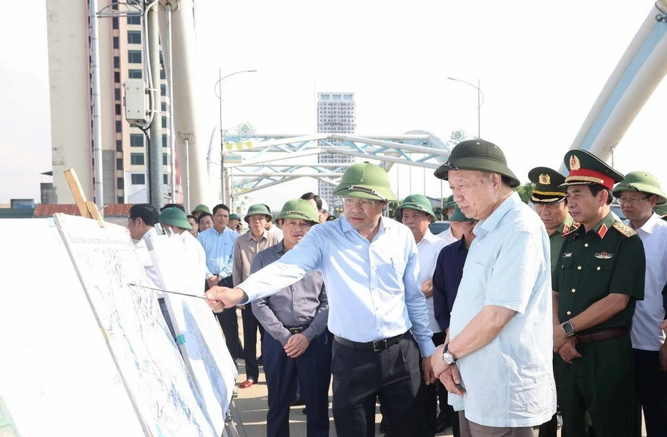 Party General Secretary To Lam listens to a leader of Thai Nguyen province report on flood and storm recovery work at Ben Tuong bridge. (Photo: VNA)