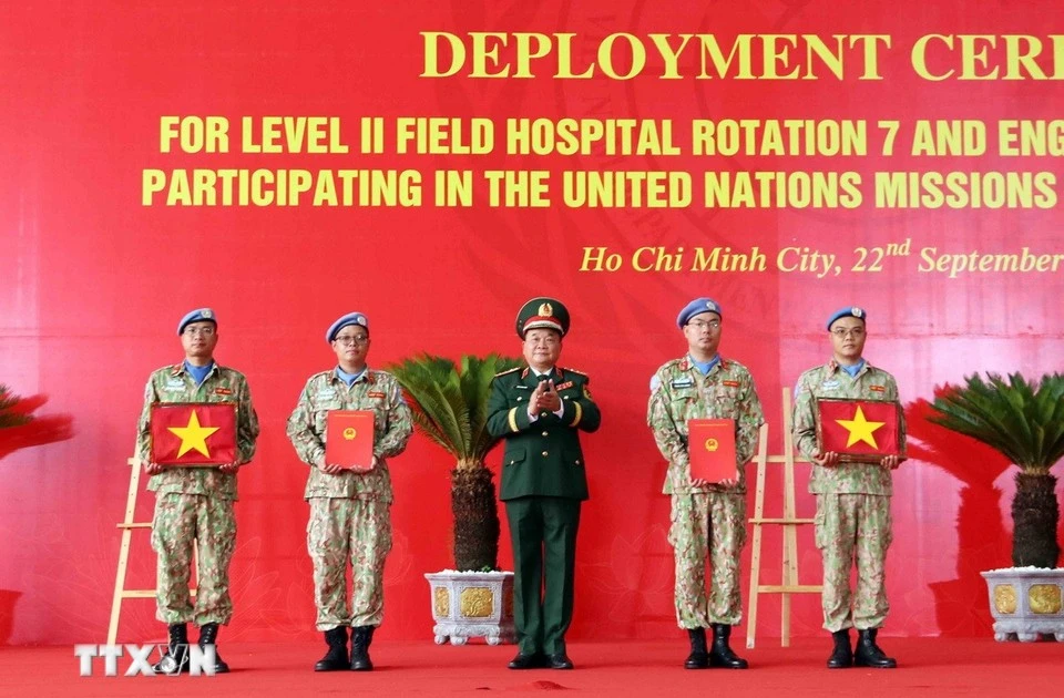 On behalf of the State President, Deputy Minister of National Defence Senior Lieutenant General Hoang Xuan Chien Hoang Xuan Chien presents the decision to Vietnamese units assigned to UN peacekeeping missions and hands over the national flag to them. (Photo: VNA)
