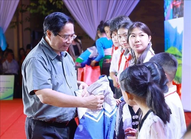 Prime Minister Pham Minh Chinh presents coats to students in Bat Mot commune,Thanh Hoa province, on October 14. (Photo: VNA)