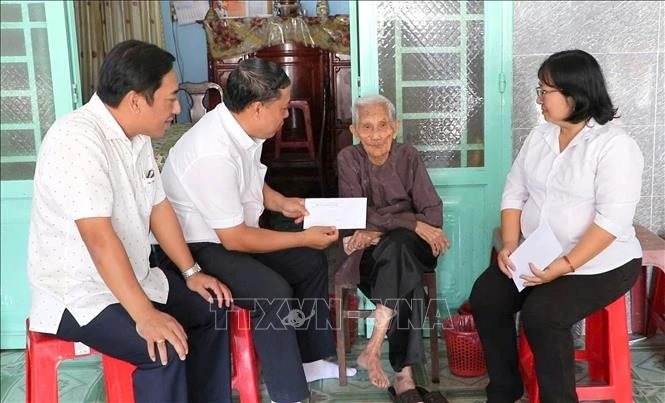 Representatives of the Party Committee, People's Council, People's Committee, and Viet Nam Fatherland Front Committee of Phu Loi Ward in Ho Chi Minh City present gifts from the Party and State to a beneficiary at her home on the occasion of the 2026 New Year. (Photo: VNA)