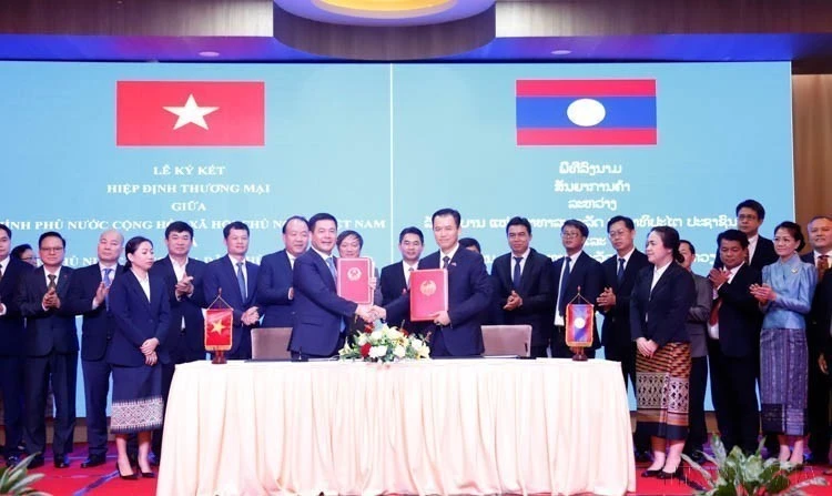 Minister of Industry and Trade Nguyen Hong Dien and his Lao counterpart Malaithong Kommasith sign the Viet Nam - Laos Trade Agreement on April 8, 2024. (Photo: VNA)