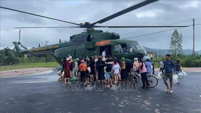 A military helicopter drops relief supplies to a flood-affected area. (Photo: VNA)