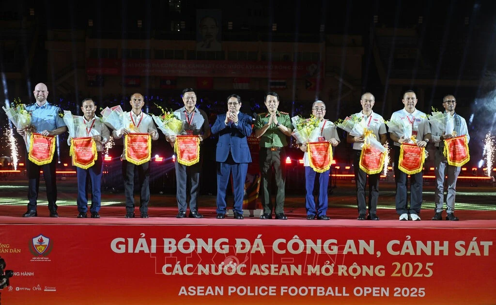 Prime Minister Pham Minh Chinh and Minister of Public Security General Luong Tam Quang present flowers and souvenir flags to heads of the football teams at the opening ceremony of the ASEAN Police Football Open 2025. (Photo: VNA)