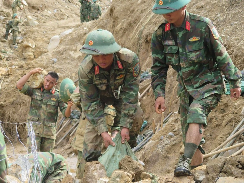 Officers and soldiers of the Army Corps 34 clear roads to reach villages isolated by floods in Ngoc Linh commune, Quang Ngai province. (Photo: VNA)