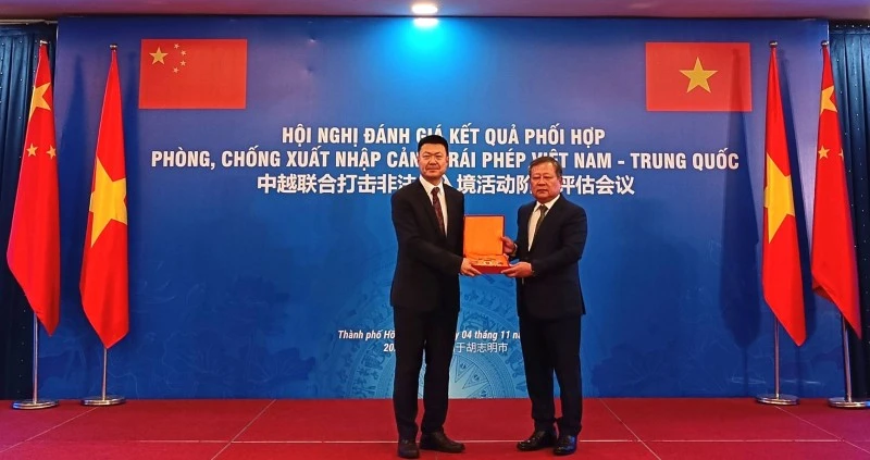 A representative of the Vietnamese delegation presents a souvenir to the Chinese delegation's representative at the conference (Photo: cand.com.vn)