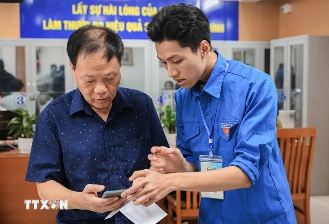 Guiding a local how to apply for administrative procedures on a mobile phone (Photo: VNA)