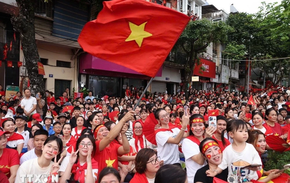 People happily welcome the forces joining in a rehearsal for the National Day parade. (Photo: VNA)