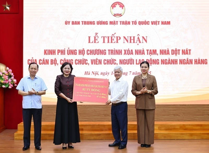 President of the Viet Nam Fatherland Front (VFF) Central Committee Do Van Chien receives the token of 82 billion VND from Governor of the State Bank of Viet Nam Nguyen Thi Hong. (Photo: VNA)
