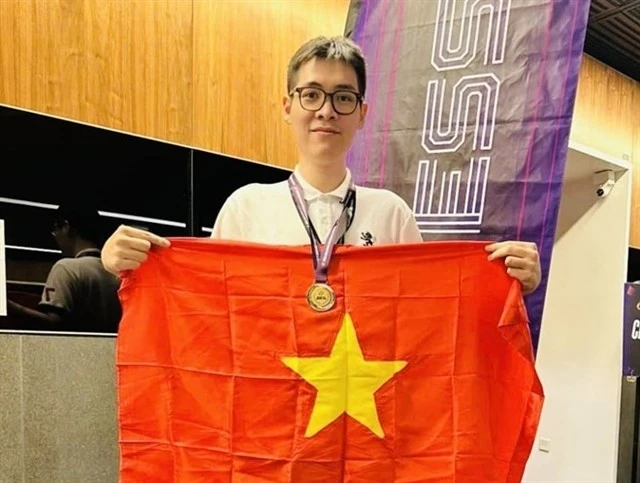 Le Tuan Minh holds the national flag to celebrate his win in rapid chess event of the Asian Mind Sports Conference & Festival which closed on November 15 in Singapore. (Photo: VNA)