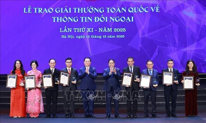 Prime Minister Pham Minh Chinh (fifth, right) presents the first prizes to the authors and groups of authors. (Photo: VNA)