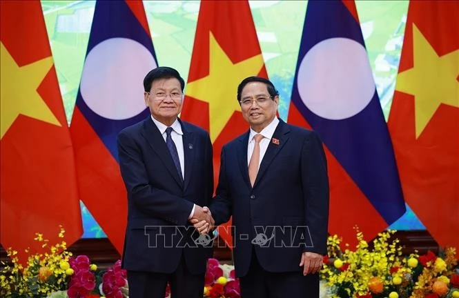 Prime Minister Pham Minh Chinh (R) and Party General Secretary and President of Laos Thongloun Sisoulith in Ha Noi on October 24 (Photo: VNA)