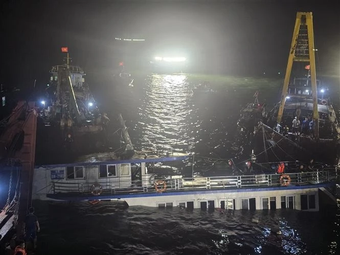 At 2:00 a.m. on July 20, rescue teams begin pumping water out of the capsized tourist boat before towing it ashore. (Photo: VNA)