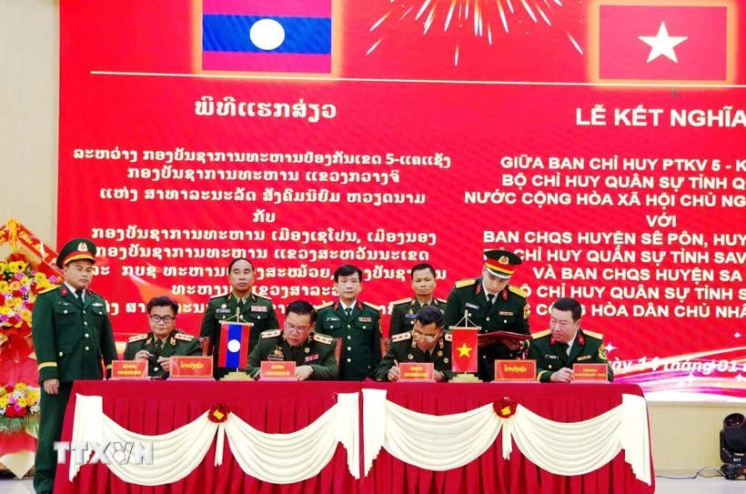 Representatives from Laos and Vietnam sign the agreement at the ceremony. (Photo published by VNA)
