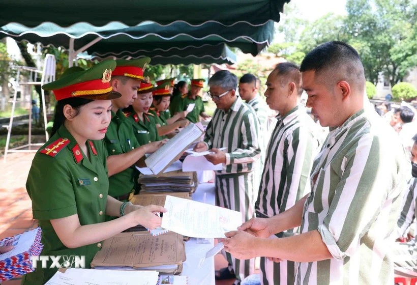 Police officers of the Phu Son 4 Prison present amnesty decisions to persons granted amnesty in 2025. (Photo: VNA)