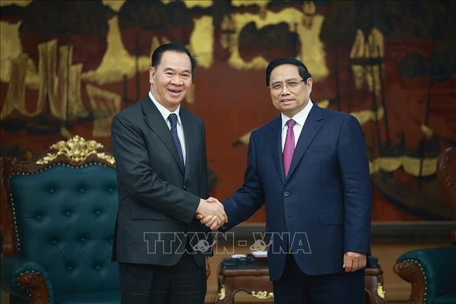 Prime Minister Pham Minh Chinh (R) receives Lao Minister of Education and Sports Thongsalith Mangnormek in Ha Noi on December 16 (Photo: VNA)