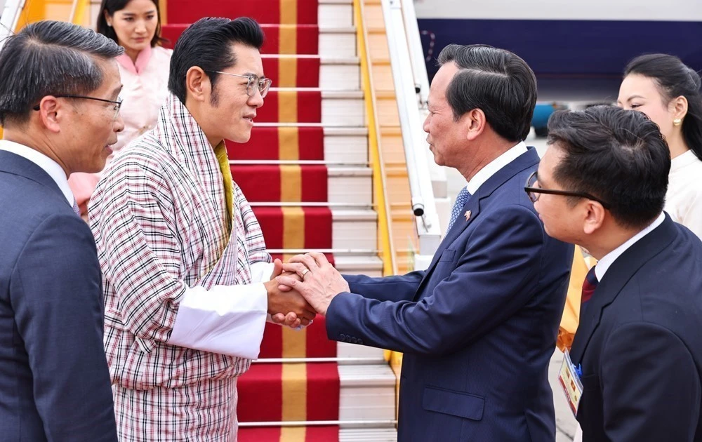 Bhutanese King Jigme Khesar Namgyel Wangchuck (second from left) is welcomed at the airport. (Photo: VNA)