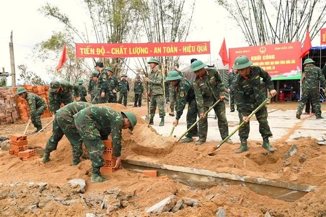 Soldiers of Military Region 5 assist residents in Dak Lak province to rebuild houses after recent floods. (Photo: VNA)