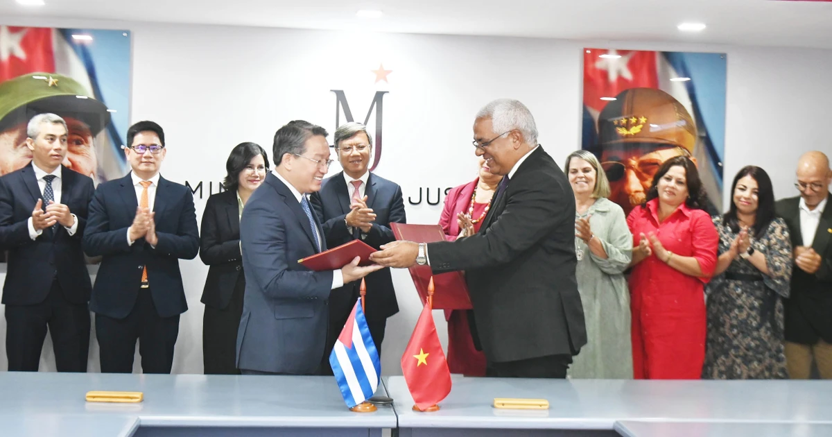Visiting Vietnamese Minister of Justice Nguyen Hai Ninh (L) and his Cuban counterpart Oscar Manuel Silvera Martínez exchange documents after signing an agreement on a technical assistance project for the Cuban Ministry of Justice. (Photo: VNA)