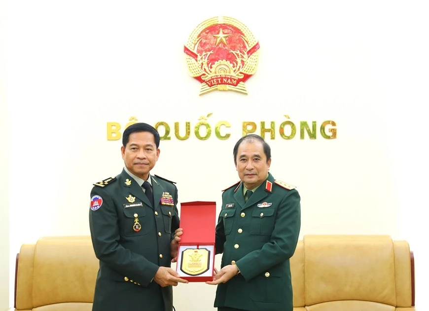 Deputy Chief of the General Staff of the Viet Nam People’s Army Sen. Lieut. Gen Phung Sy Tan presents a souvenir to Gen. Phorn Nara, Secretary General of the National Authority for the Prohibition of Chemical, Nuclear, Biological and Radiological Weapons of Cambodia (CBRNE) in Ha Noi on December 23 (Photo: qdnd.vn)