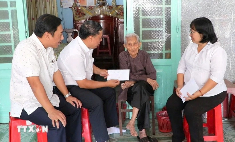 Leaders of the Party Committee, People's Council, People's Committee, and Viet Nam Fatherland Front Committee of Phu Loi ward, Ho Chi Minh City, present gift from the Party and State to a social assistance recipient at her home on the occasion of the 14th National Party Congress and the 2026 Lunar New Year. (Photo: VNA)