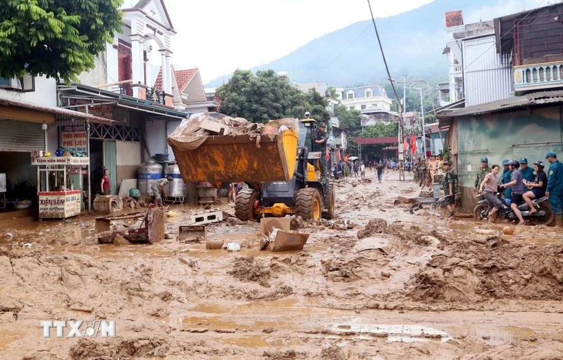Excavators are deployed to help clear mud, fallen branches, and debris swept in by recent floods in Song Ma commune, Son La province. (Photo: VNA) 
