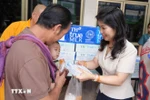 Vu Thi Dung, spouse of Vietnamese Ambassador to Laos Nguyen Minh Tam, presents gifts to the needy. 