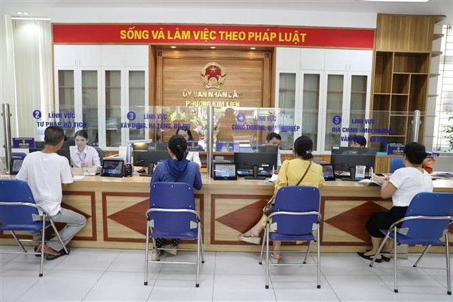 People come to conduct public administrative procedures in Kim Lien ward. (Photo: VNA) two-tier-local-administration-2.jpg