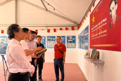 A representative of Nhan Dan Newspaper introduces an exhibition on President Ho Chi Minh and Vietnam’s struggle for independence to Lao Ambassador to France Kalamoungkhoune Souphanouvong (centre). (Photo: VNA)
