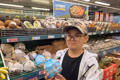 An Asian customer with a Vietnamese coconut product served with straws (Photo: VNA)