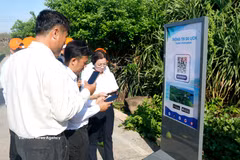 Tourists scan the QR Code to access travel information at the sovereignty flagpole of Phu Quy Special Zone in Lam Dong province. (Photo: VNA)