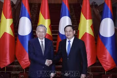 Party General Secretary To Lam (left) meets with Lao Prime Minister Sonexay Siphandone on February 5 in Vientiane. (Photo: VNA)