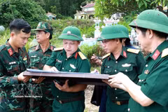 Colonel Ha Van Ai, Deputy Political Commissar of the Hue City Military Command (third, left), and other officials discuss the burial location of fallen soldiers on a map. (Photo: VNA)