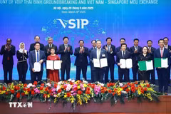 Prime Minister Pham Minh Chinh and his Singaporean counterpart Lawrence Wong witness the exchange of cooperative documents between Vietnamese and Singaporean enterprises in Hanoi on March 26. (Photo: VNA)