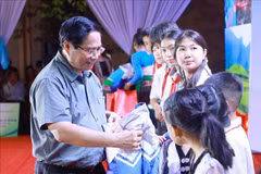 Prime Minister Pham Minh Chinh presents coats to students in Bat Mot commune,Thanh Hoa province, on October 14. (Photo: VNA)