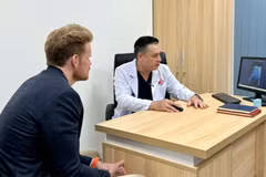 D.F (left), a US patient, at a follow-up examination with Do Lenh Hung, head of the department of urethral reconstructive surgery. (Photo: VNA)