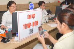 A citizen scans a QR code to look up procedures and processes related to judicial and civil registration matters. (Photo: VNA)