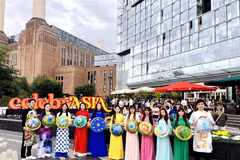 The Vietnamese delegation parades in traditional ao dai and conical hats along the streets of London. (Photo published by VNA) 