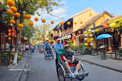 Tourists relax on eco-friendly cyclo rickshaws while exploring Hoi An's ancient town. (Photo: VNA)