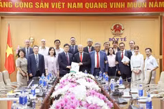 Standing Deputy Minister of Health Vu Manh Ha, General Secretary of the Mexican Labour Party Alberto Anaya Gutierrez and other officials pose for a group photo. (Photo: VietnamPlus)