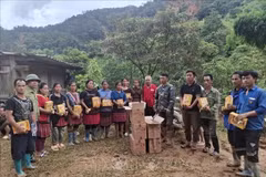 A representative of the Dien Bien Red Cross Society presents relief supplies to local residents. (Photo: VNA)